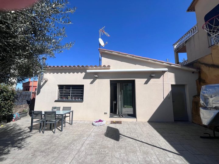 Fachada después de la reforma: porche integrado en la vivienda con gran puerta corredera
