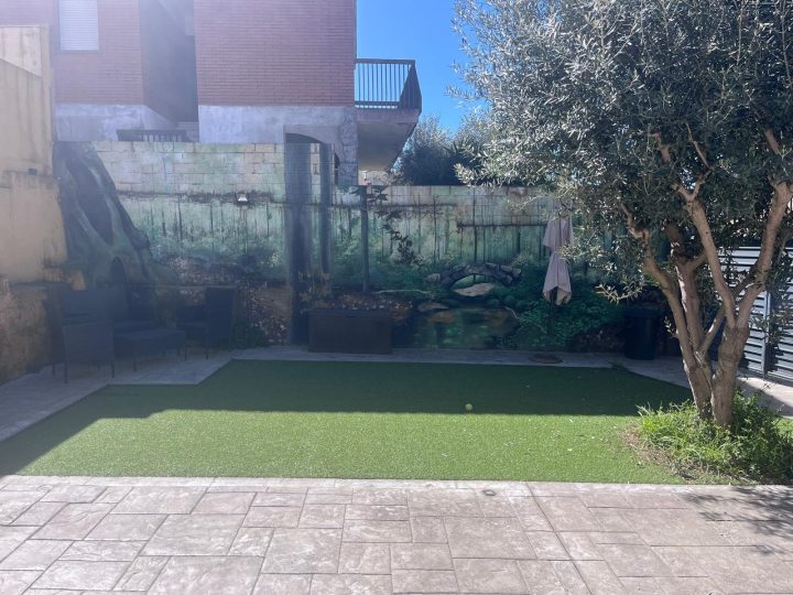 Patio después de la reforma: nuevo pavimento, césped y zona de estar